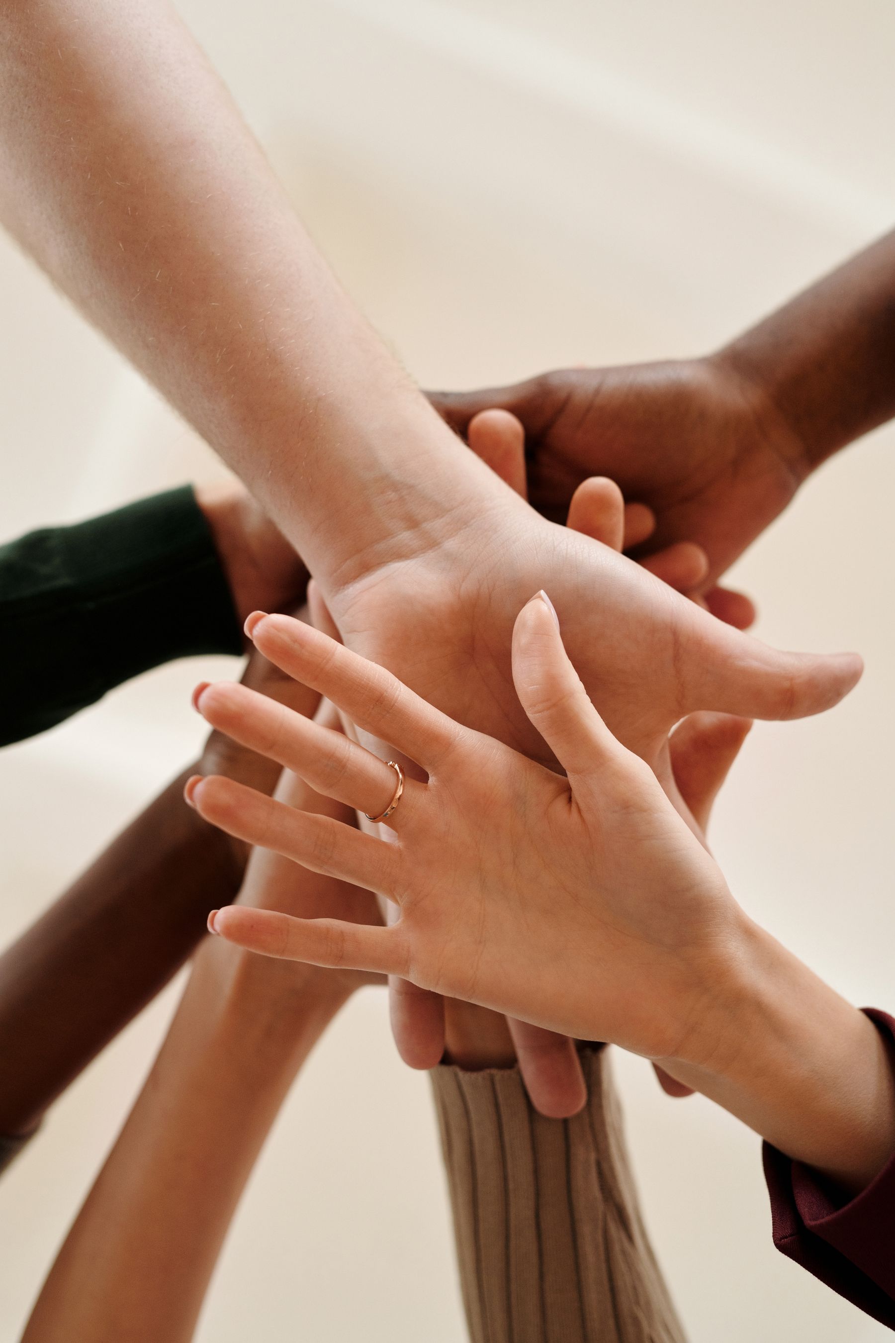 Two pairs of hands held together in support